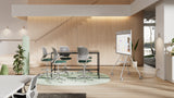 An image of an open office space. There is a table along with five chairs in the middle of the room. Logitech Rally Board 65 is in front of the table, mounted to a cart.