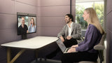A photo of a man and a woman in a small meeting space, seated at a table. The woman has a laptop on her lap and, on the table, directly in front of them, is the Neat Board 32, attached to an adaptive table stand. The Neat Board 32 screen shows another man and woman, all appearing to be on a live video call.